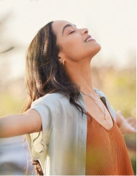 Woman embracing nature with open arms, symbolizing inner healing
