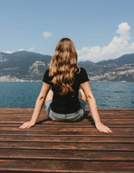 Woman sitting peacefully by a lakeside